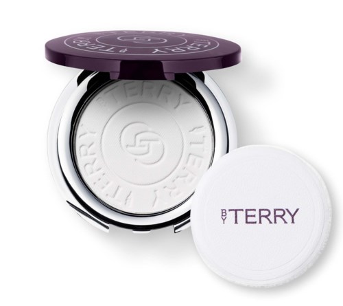 En lila kompaktlåda med vitt puder inuti och en vit puderborste med lila text som säger "BY TERRY."