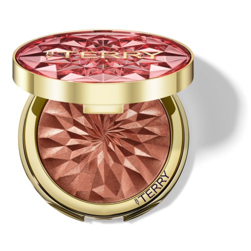 En dekorativ kompakt med rosa edelstiendesmønster på toppen, inneholder bronser, merket av By Terry.