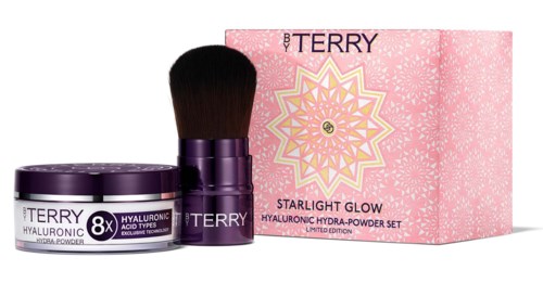 A skincare set with a cream jar, brush, and pink box labeled 'Starlight Glow' by Terry.