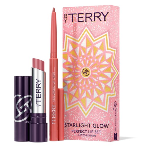 Et rosa læbe gloss og læbestift sæt med en dekorativ æske, mærket 'By Terry Starlight Glow Perfect Lip Set.'