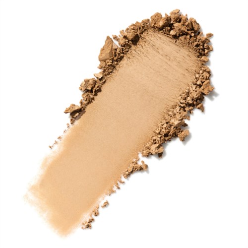 En beige pulver spredt ut med noen løse biter rundt kanten.