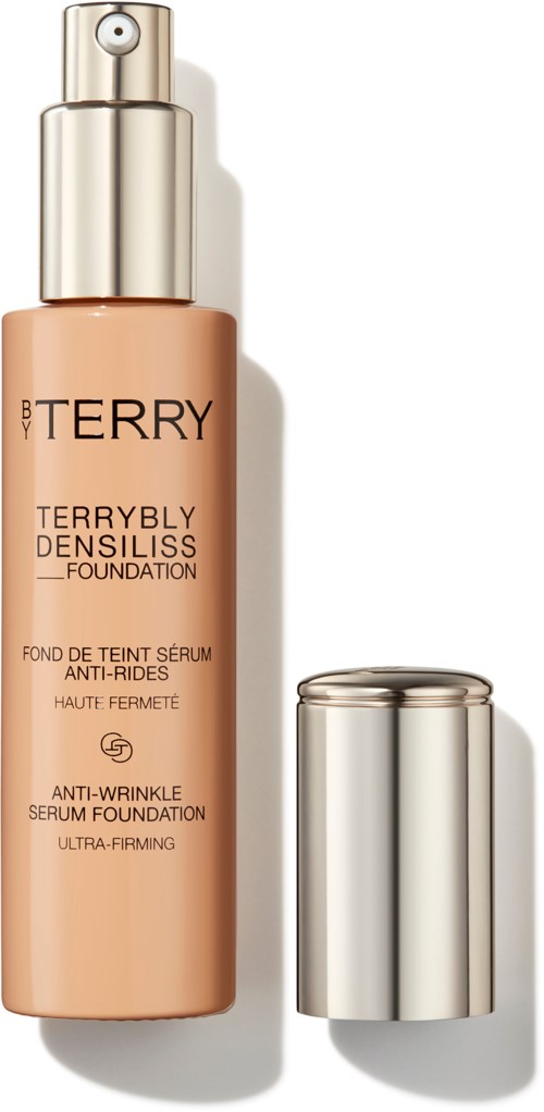En beige flaska med silverlock, märkt 'BY TERRY', innehåller foundation för hudvård och smink.