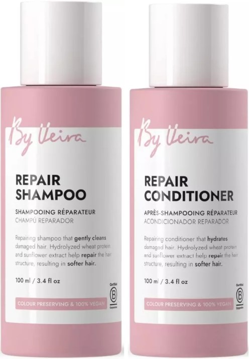 Two pink bottles of hair repair shampoo and conditioner with white caps, labeled with brand and product details.