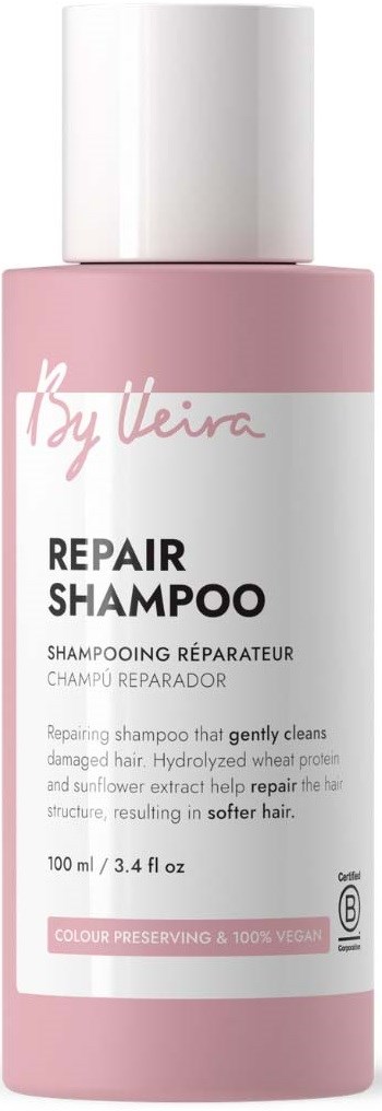 Pink bottle of Repair Shampoo with a white cap, label indicating it gently cleans damaged hair and is vegan.
