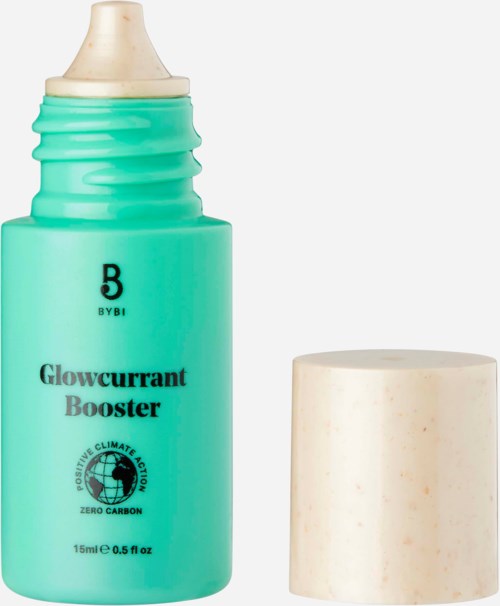 En tealfärgad flaska märkt 'Glowcurrant Booster' med en beige lock i närheten, används för hudvård eller kosmetiska ändamål.
