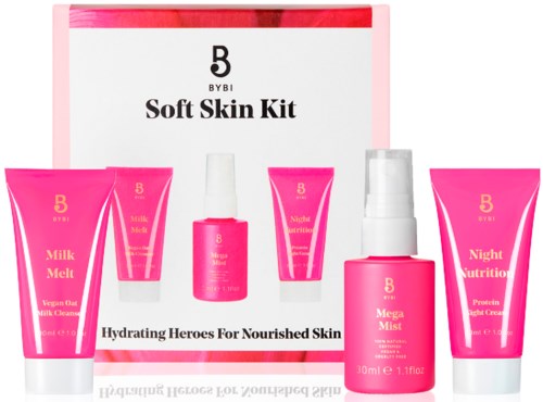 Lys rosa hudpleieprodukter og en eske merket "Soft Skin Kit" med tekst om hydrering og nattnæring.