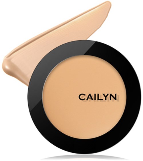 En kompakt foundation i beige farge i en svart sirkelbeholder og en beige kost.