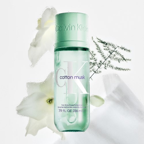 Calvin Klein katoen musk parfumfles met witte bloemen en groene bladeren eromheen.