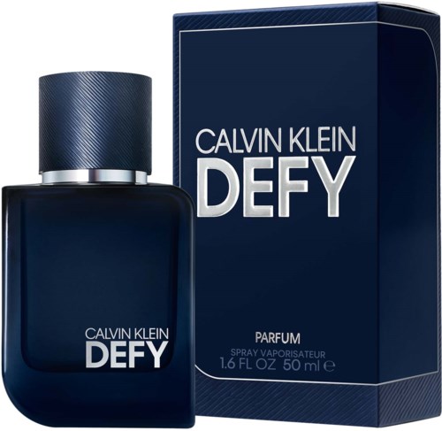 Een donkerblauwe parfumfles met een getextureerde dop, naast een matchende doos met witte tekst. Het zegt 'Calvin Klein Defy' en 'Parfum.'