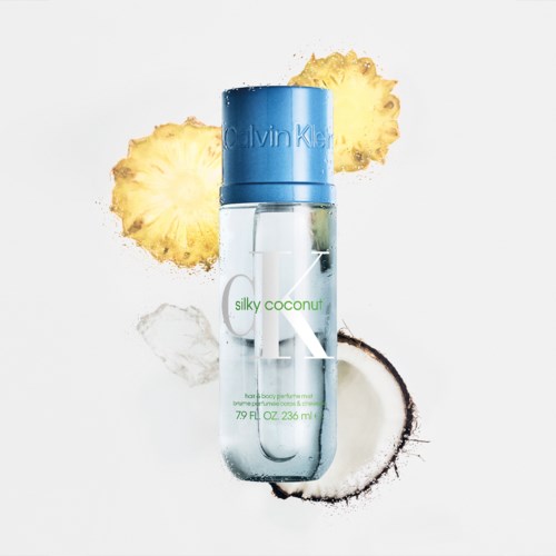 Een heldere fles Calvin Klein Silky Coconut parfums met ananas- en kokosstukken eromheen.