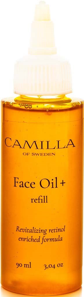 En lille flaske med ansigtsolie med hvid dyse, indeholder orangefarvet olie, mærket som Camilla face oil plus refill.