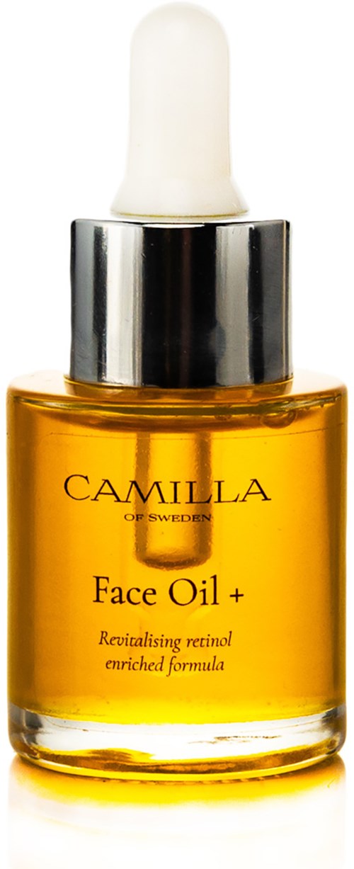 Pieni tummansininen lasi sarja kasvoöljyä, valkoinen pisara-typpinen korkki ja hopeinen nauha. Etiketti lukee "CAMILLA Face Oil +."