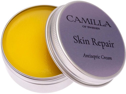 Een ronde pot met gele crème erin, gelabeld 'Camilla Skin Repair Antiseptic Cream' uit Zweden.