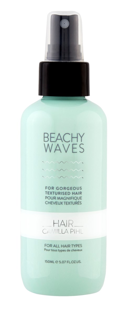 En lyseblå sprayflaske merket 'Beachy Waves' for teksturert hår, med svart sprayhode og hvit etikett.