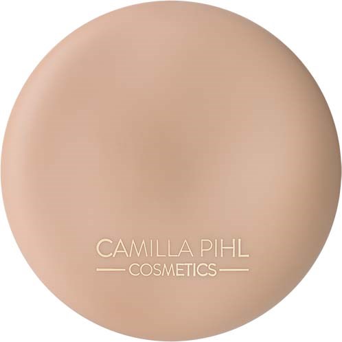 En rund beige sminkegrunnkremsboks med varemerket Camilla Pihl Cosmetics.