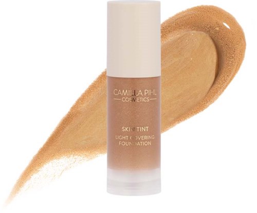 A bottle of Camilla Pihl Cosmetics skin tint foundation with a swatch showing light coverage.