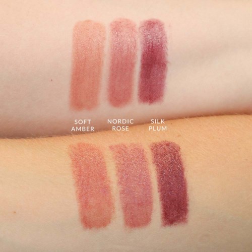 Swatches of three makeup shades labeled Soft Amber, Nordic Rose, and Silk Plum on skin.