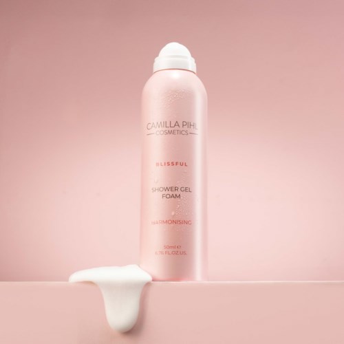 Rosa duschgelsflaskor märkt Camilla Pihl Cosmetics Blissful. Skum spillde på ytan nedan.