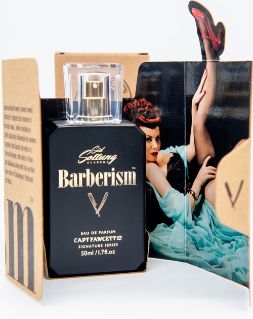 En parfume flaske mærket 'Barberism' med bokse og kunst bagved.