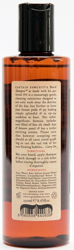 A tall, orange bottle with a black cap and a label with text about shampoo.