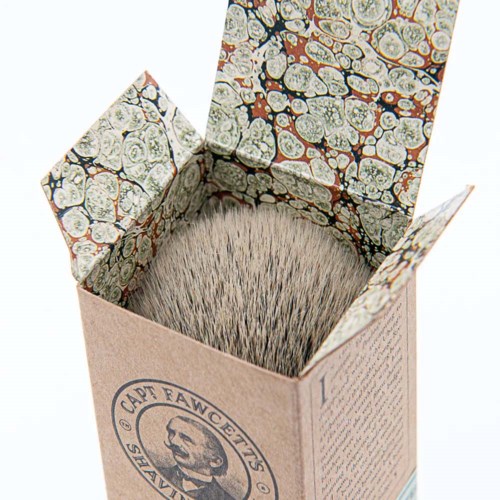 A cardboard box with a beard illustration and text, open to show densely packed bristles inside.