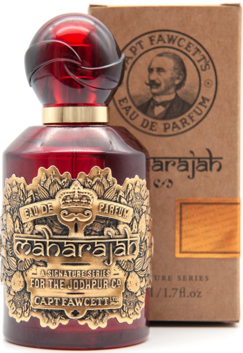 Eine rote Parfümflasche mit verziertem Etikett und braunem Karton mit Porträt. Die Flasche ist rund.