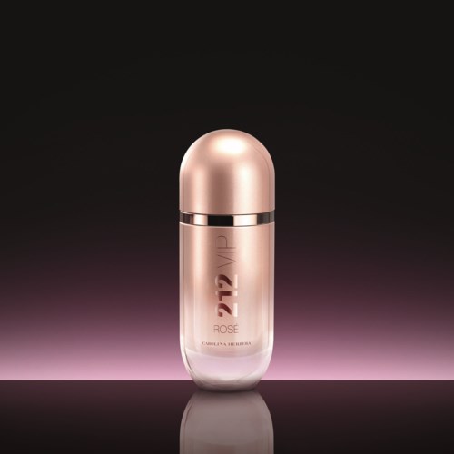 Een parfumfles met een roségouden dop en een doorzichtige huid, gemarkeerd 212 VIP en Rose, op een donkere achtergrond.