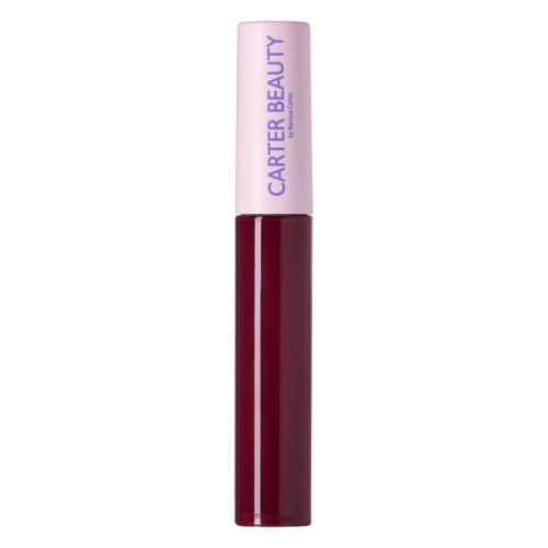 En läppstift i mörkröd nyans med ett rosa stiftlock med texten 'CARTER BEAUTY' på i lila bokstäver.