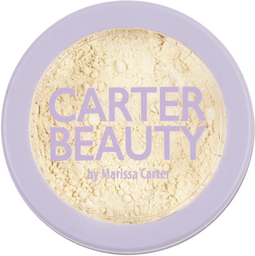 En runt behållare med lila lock och gult pulver inuti. Etiketten visar 'Carter Beauty by Marissa Carter.'