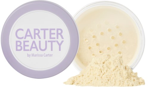Crèmepulver i en öppen burk märkt 'Carter Beauty by Marissa Carter'.