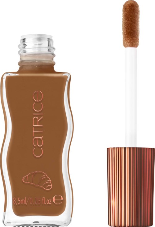 En foundationflaska med en metallkapsyl och en applicator med brunt foundation på.