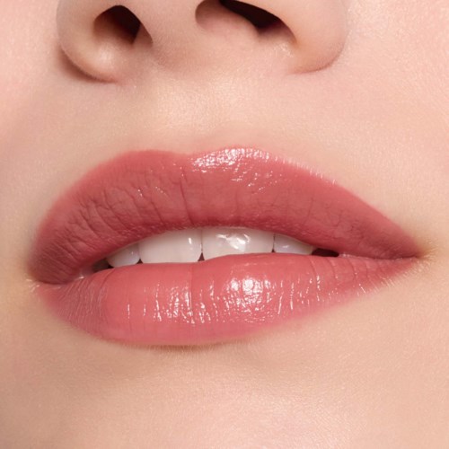 Nærbilde av lepper med rosa gloss og litt synlige tenner.