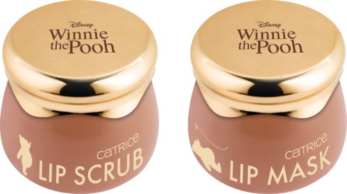 Två Winnie the Pooh-läppvårdsbehållare, en märkt 'Lip Scrub' och den andra 'Lip Mask,' båda med guldluckor.