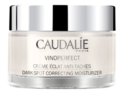 En burk med Caudalie Vinoperfect mörka fläckar rättande fuktighetskräm med lock i glänsande silver.