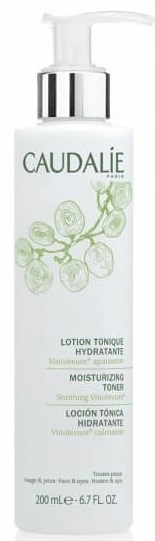 En vit flaska med pump, märkt Caudalie, innehåller återfuktande och lugnande ansiktsvatten med druvillustration.