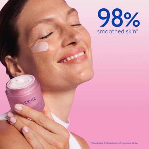 Smilende kvinde med glat hud holder en pink hudpleje krukke og promoverer 98 % glattere hud.