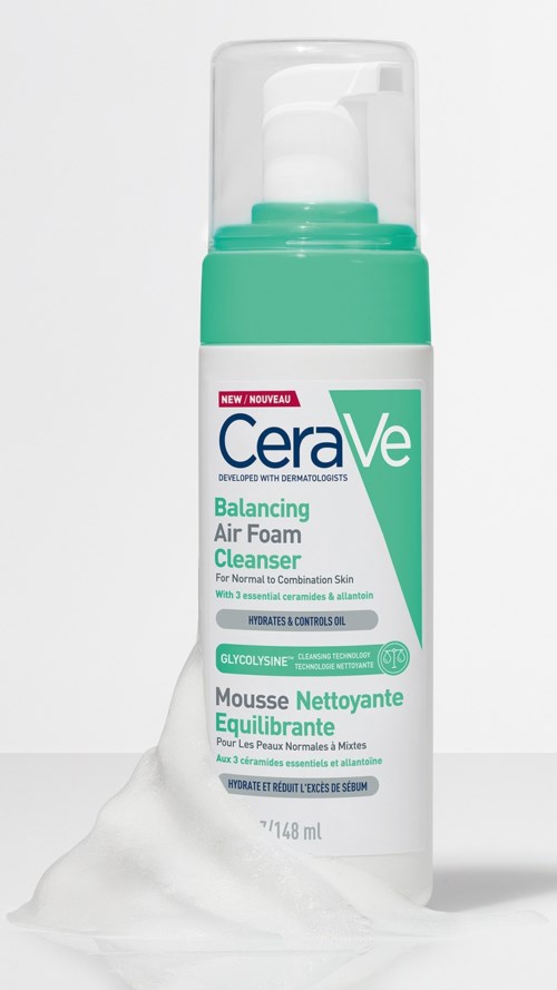 Een witte en groene fles CeraVe Balancing Air Foam Cleanser met schuim dat eruit stroomt.