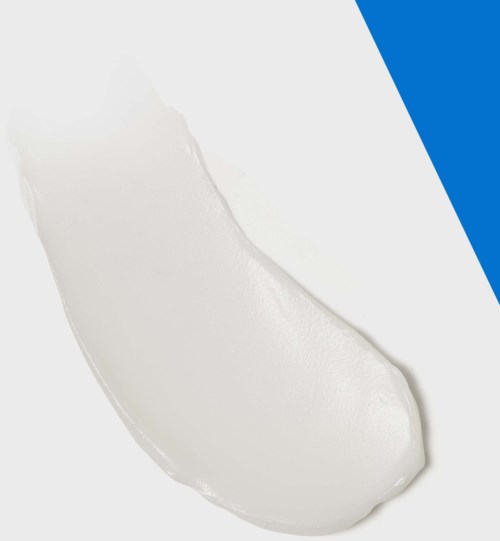 En sked med vit kräm eller yogurt på en enkel yta med blå och svarta inslag.