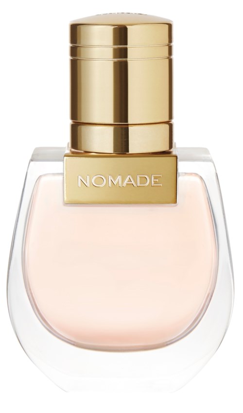 A perfume bottle with a clear glass body, gold cap, and a label that says "NOMADE."