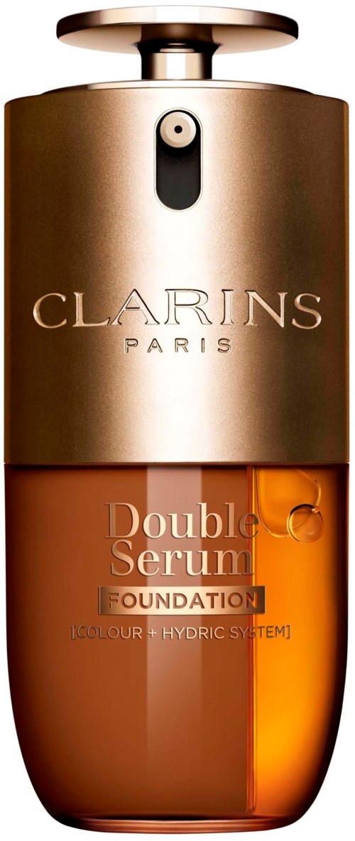 En Clarins Paris-foundationsflaska med guldkork, transparent orange vätska inuti och logo på framsidan.