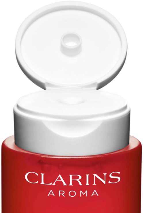 Punainen purkki, jossa on valkoinen teksti ja valkoinen kansi auki päällä, merkinnällä "Clarins Aroma."