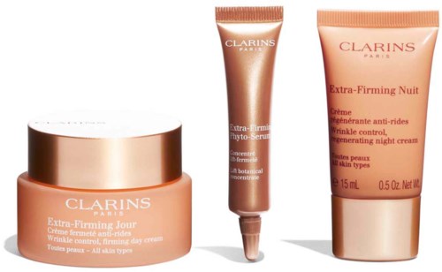 Three skincare products from Clarins, including day cream, serum, and night cream, all in peach-colored containers.