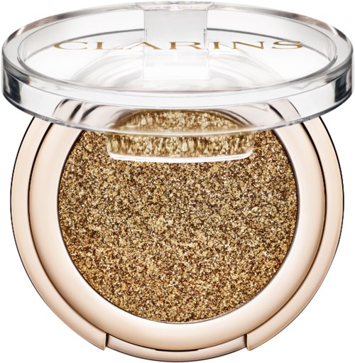 Ett runt sminkkompakt med guldglitter inuti och ett tydligt lock med texten "Clarins."