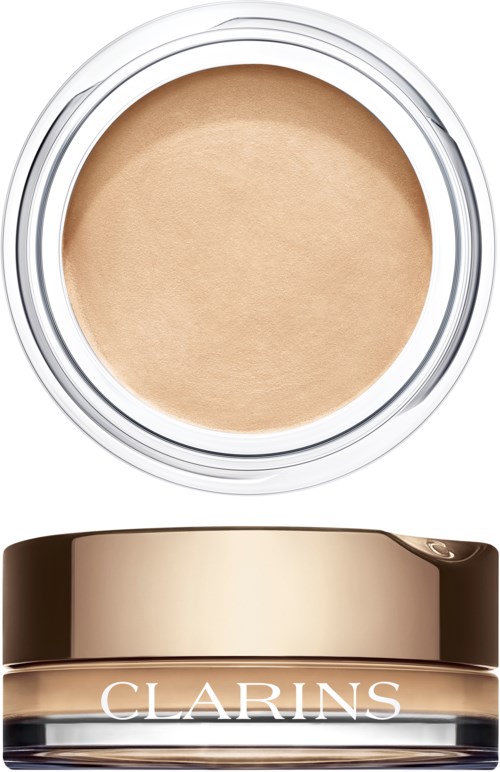 En kompaktdosa med beige puder och ett mörkgylligt lock med Clarins-loggan.