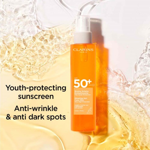 Clarins solkräm med SPF 50+ omgiven av en skål av guldiga och klara vätskor.