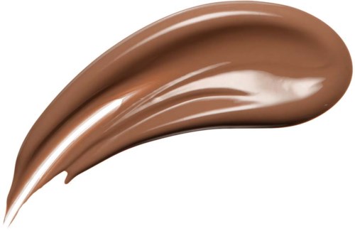 A smooth, brown, creamy substance spread in a curved shape on a black background.