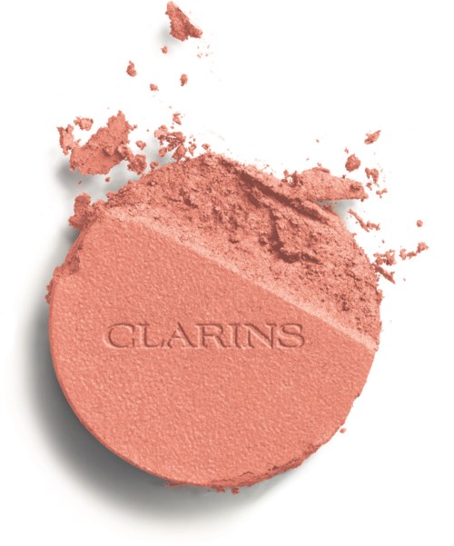 Różowy prasowany puder z nadrukiem 'CLARINS', trochę pudru wokół.