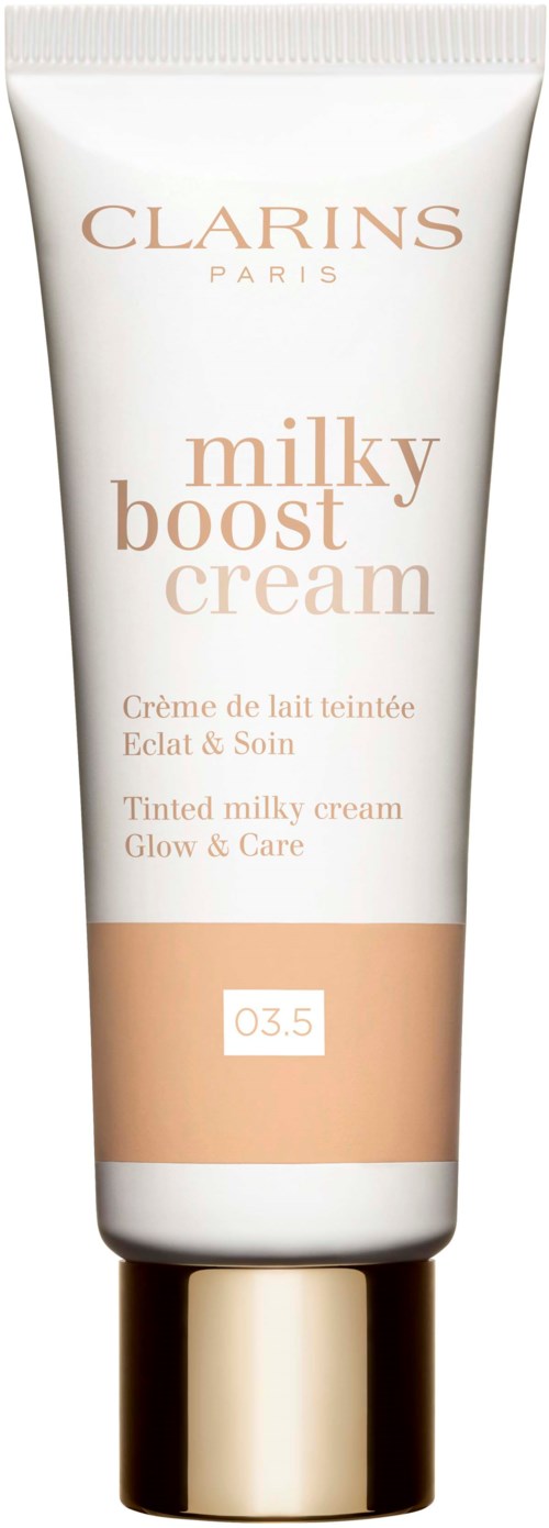 En vit tub med Clarins Milky Boost Cream med beige text och en guldlock.
