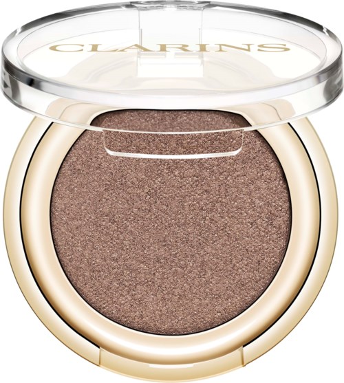 Ett runt makeup-kompakt med bronzig ögonskugga eller highlighter och ett tydligt lock med varumärket 'CLARINS'.