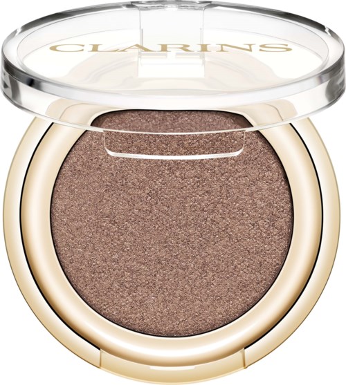 En rund makeup-kompakt med beige och guldtoner, innehållande brun ögonskugga och ett transparent lock med varumärkesnamnet Clarins.